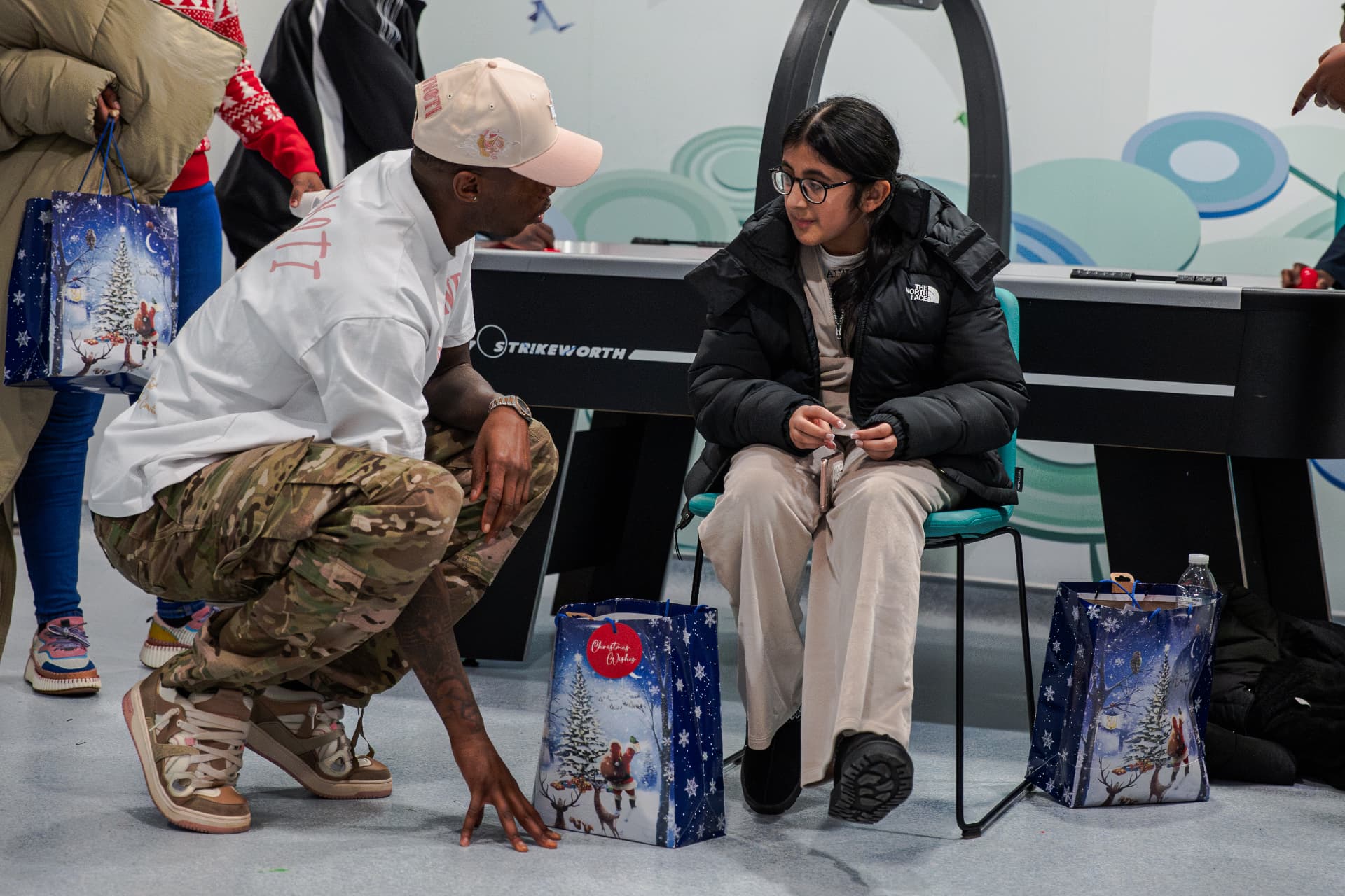 Kofi Josephs speaking with a young person during a Wings of Hope Christmas activation