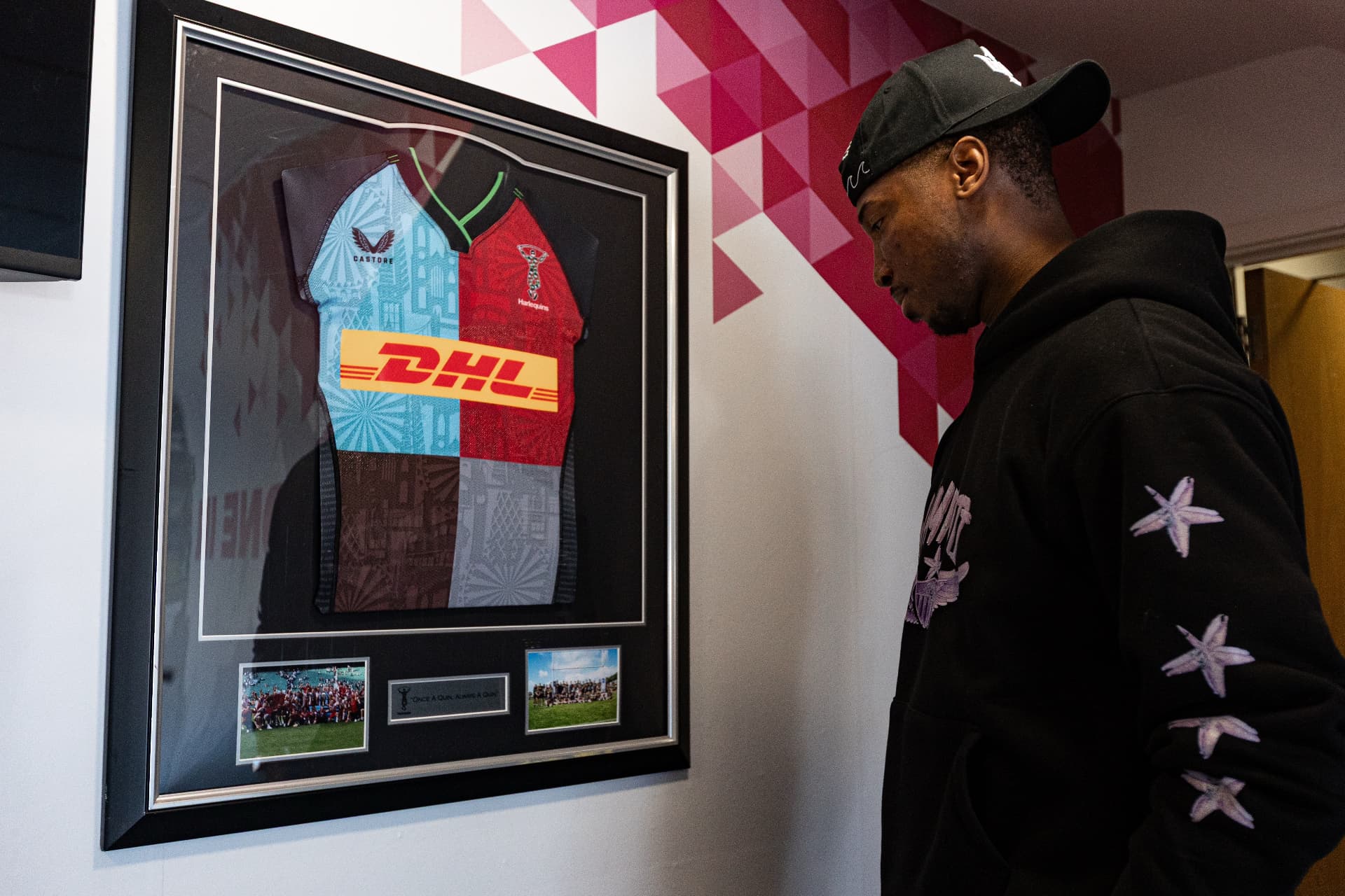 Kofi Josephs viewing a framed Harlequins shirt inside the club building