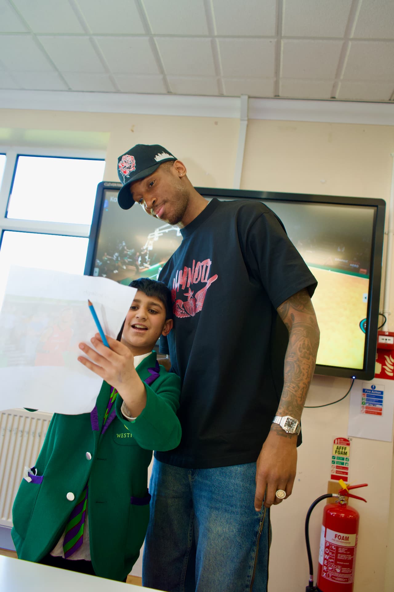 Kofi Josephs looking at a Westholme pupil’s written work in the classroom