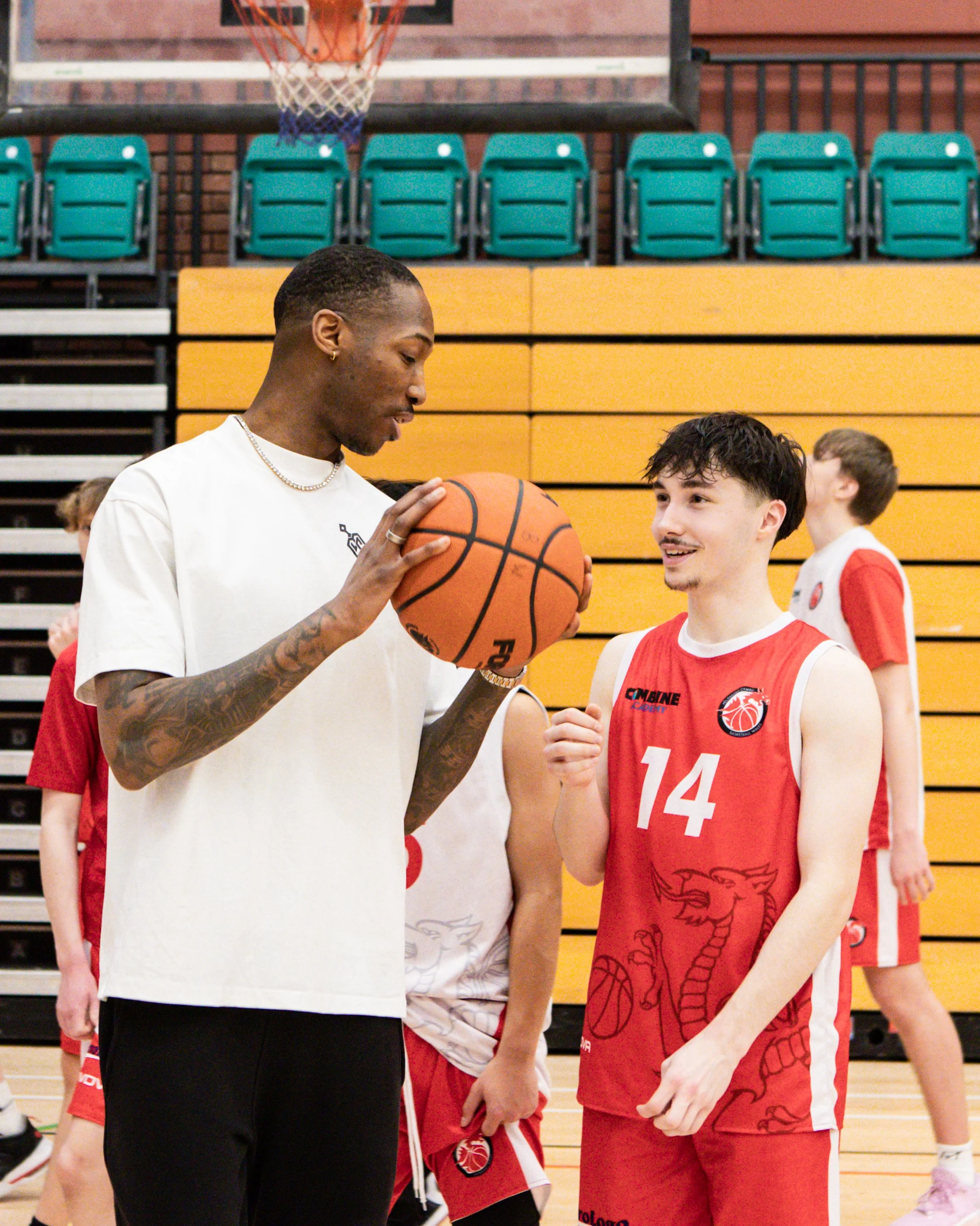 Kofi Josephs in conversation with a Basketball Wales player