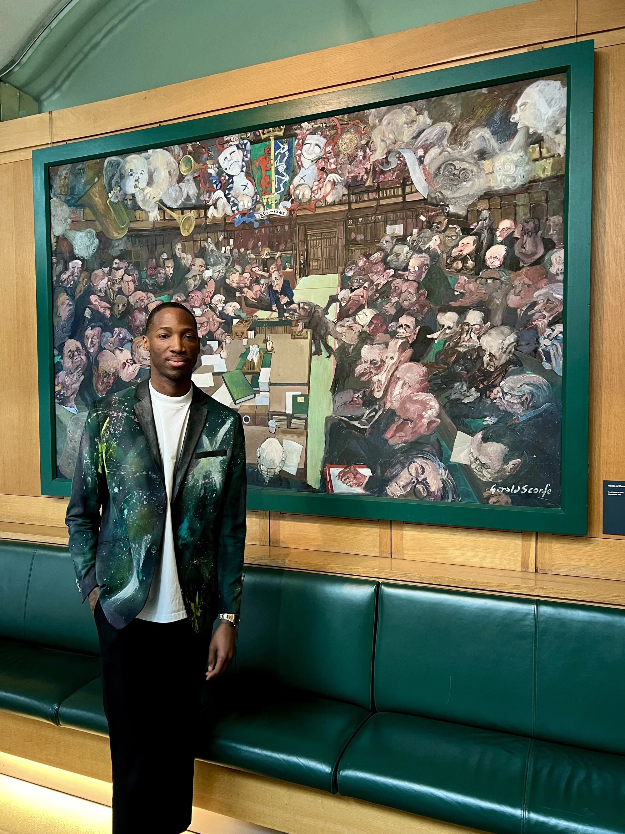 Kofi Josephs inside the parliamentary setting beside artwork depicting the House of Commons