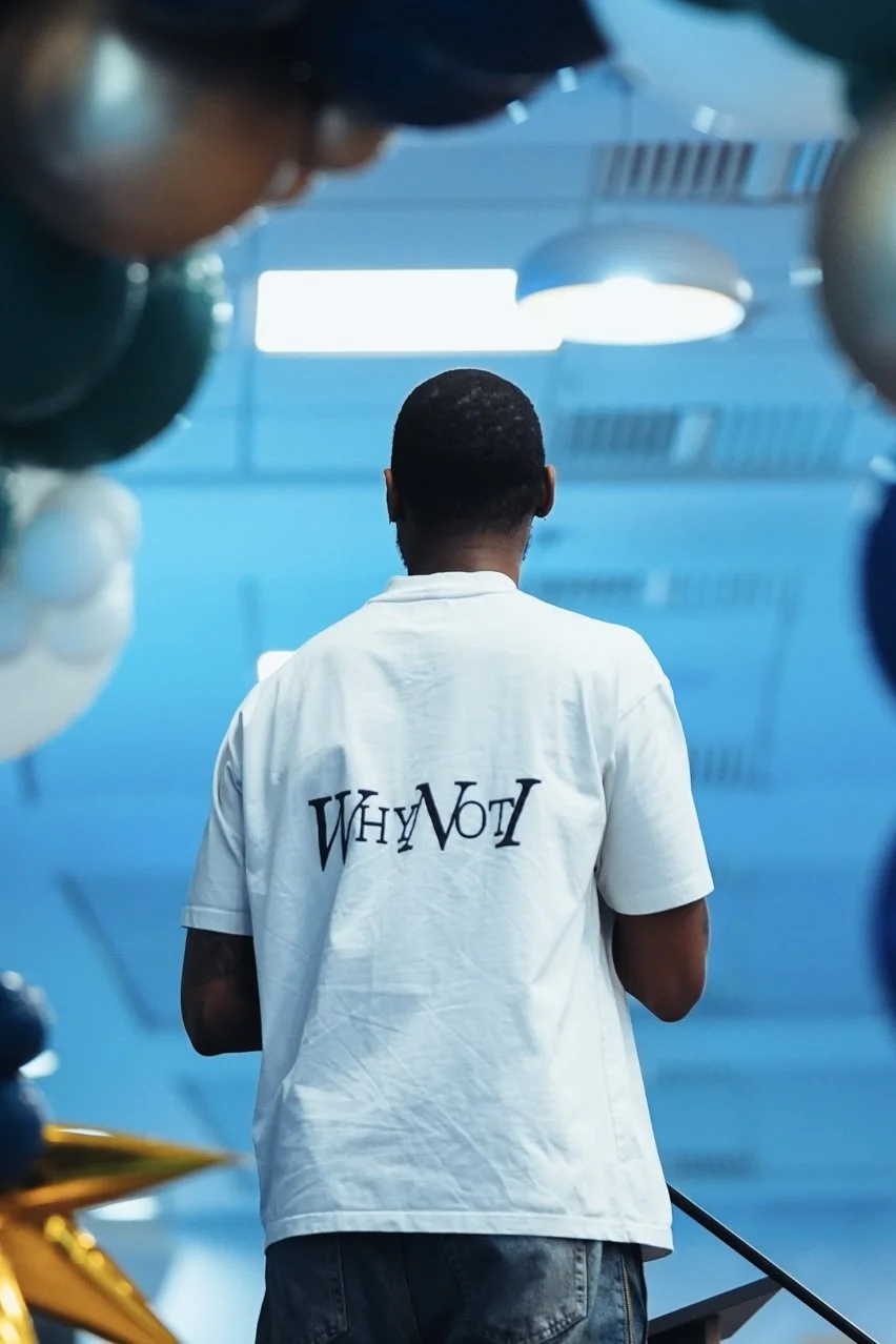 Kofi Josephs seen from behind wearing a Why Not I shirt