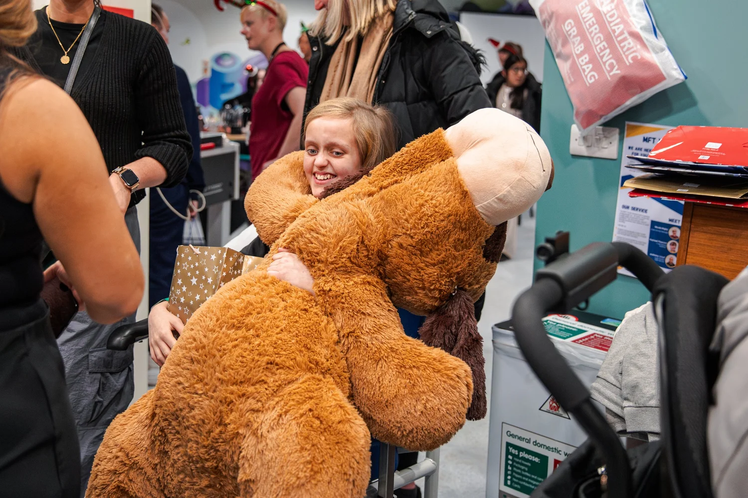 A child receiving a teddy bear during the Manchester Royal Children's Hospital Christmas activation