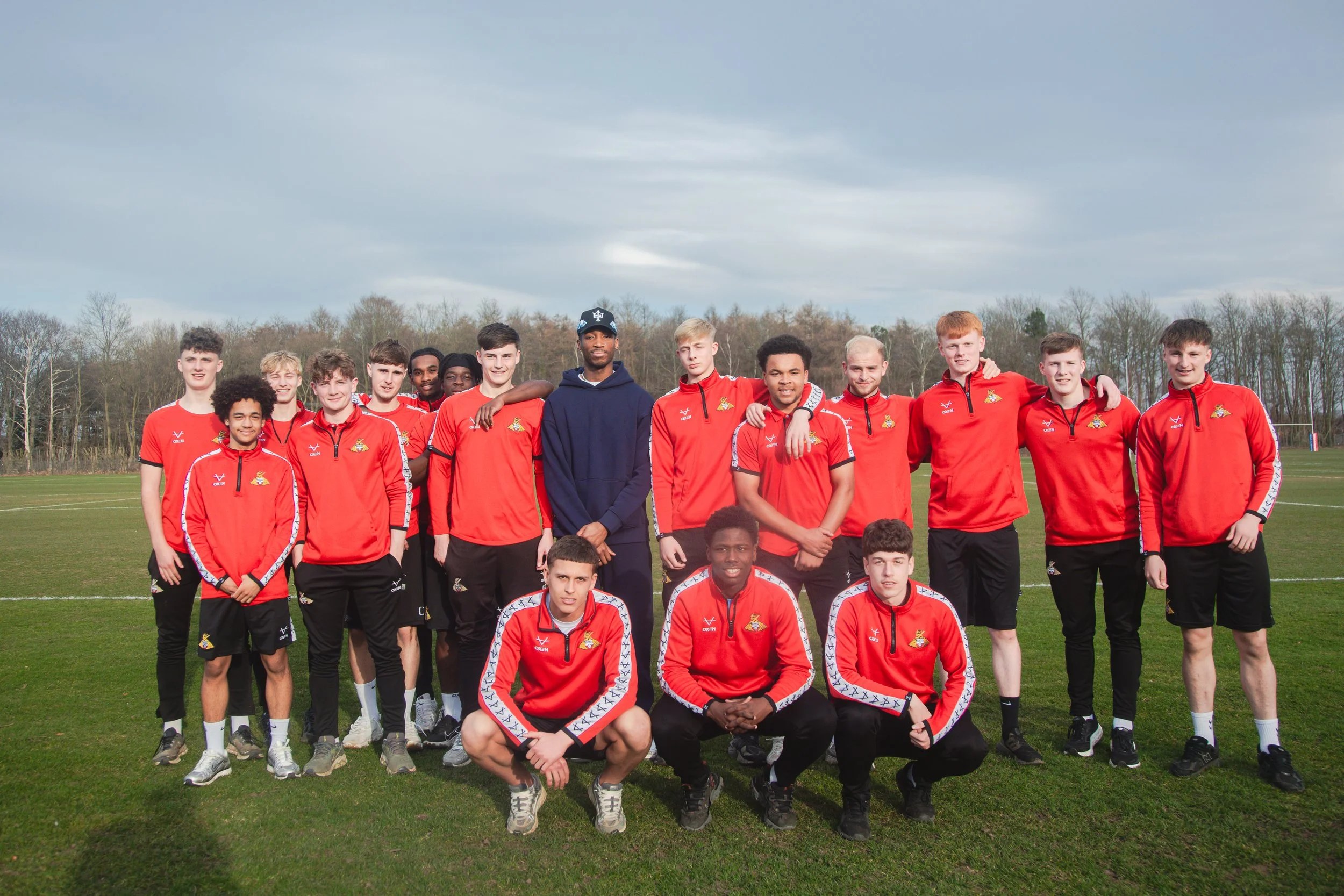 Kofi Josephs with Doncaster Rovers Academy players beside the training pitches
