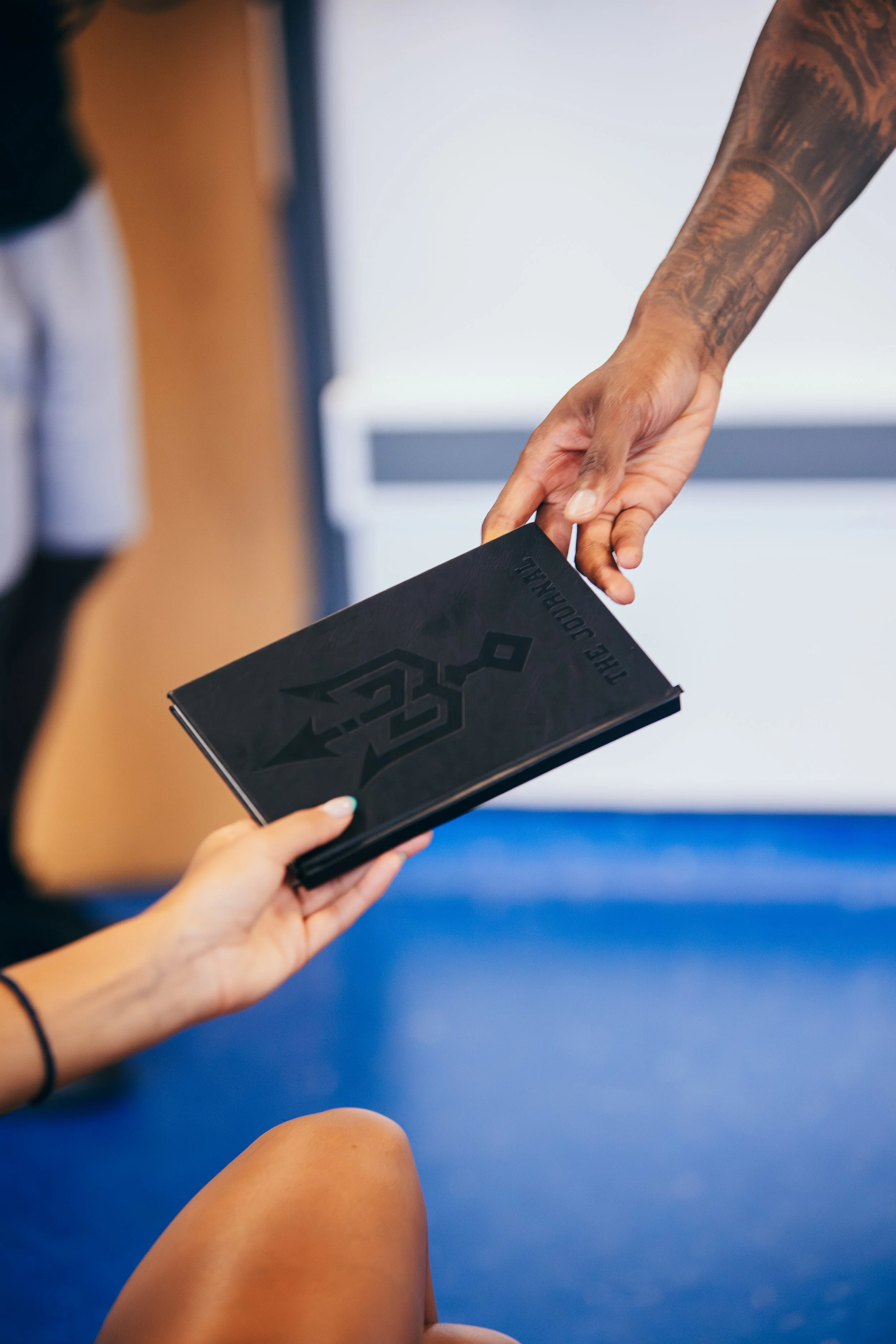 A participant receiving a Why Not I booklet during the 2024 Workout