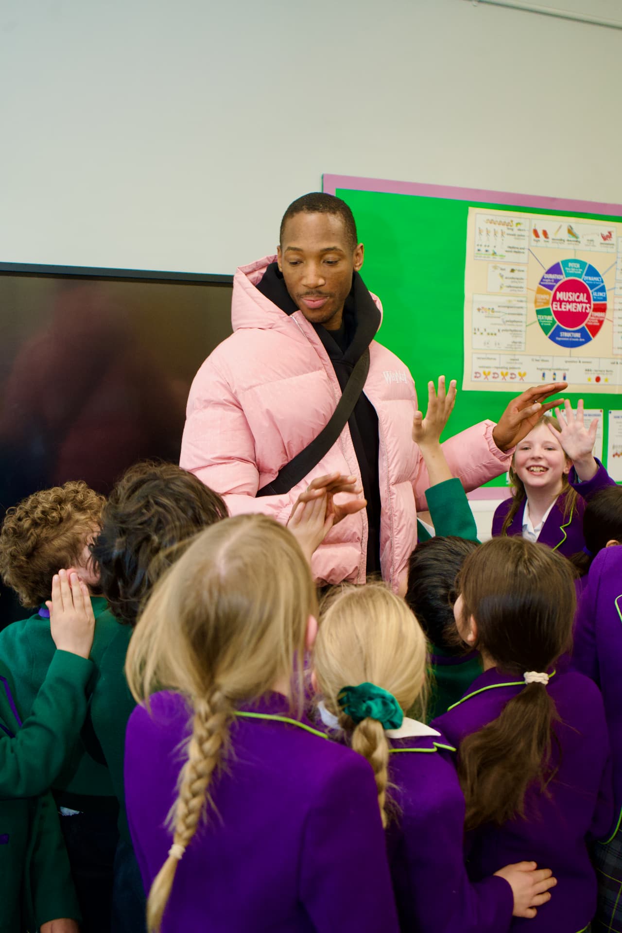Kofi Josephs high-fiving Westholme pupils in the classroom
