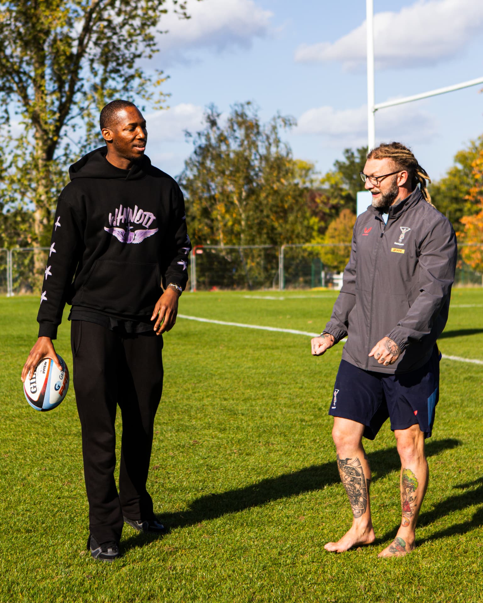 Kofi Josephs talking with a member of the Harlequins team on the pitch