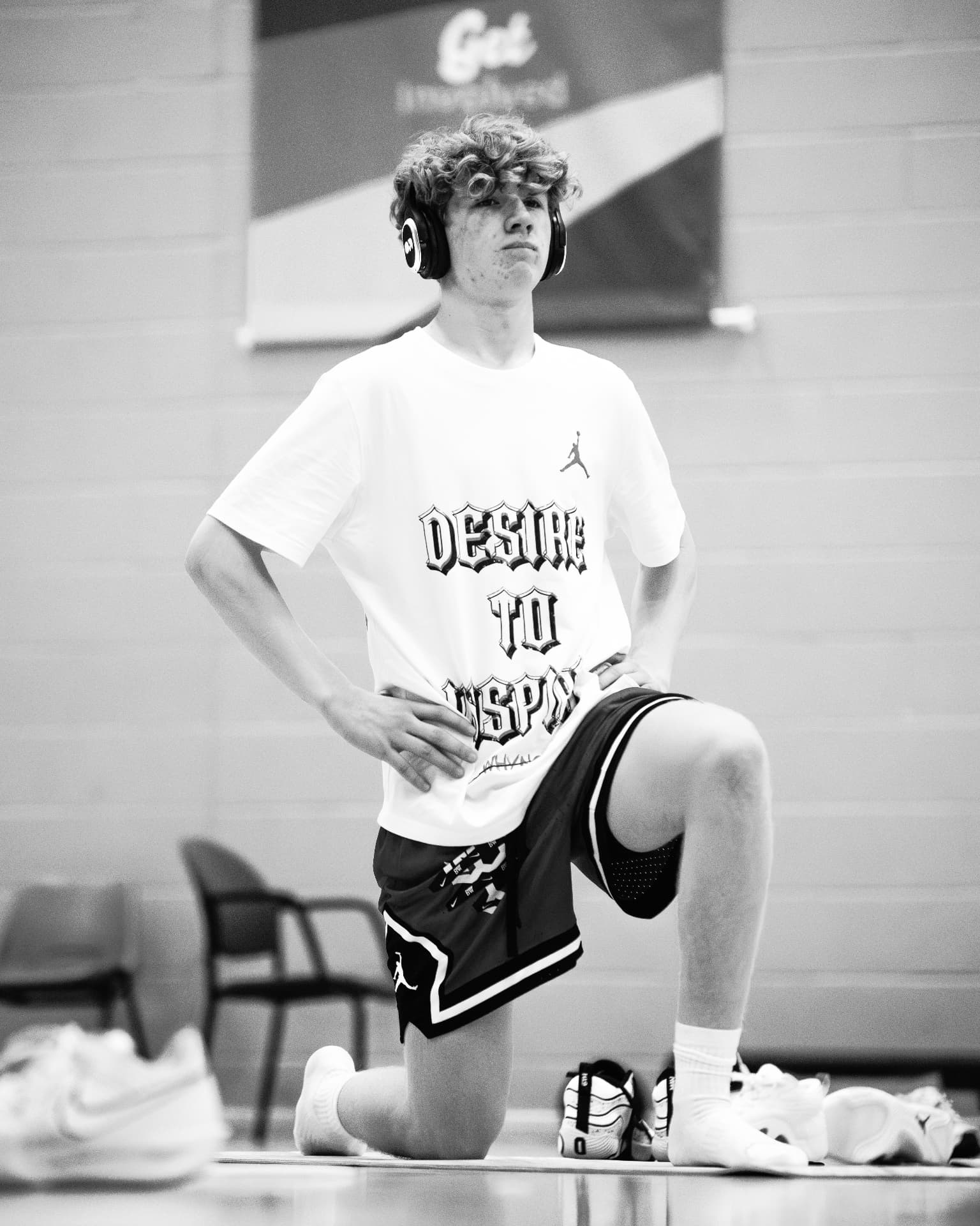 A participant in headphones stretching during a warm-up drill at the 2025 Workout